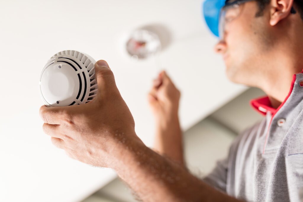 engineer installing smoke alarm